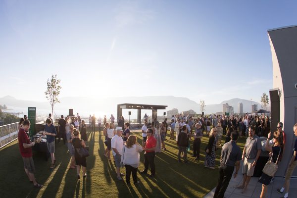 Rooftop event with large crowd, live music, on the rooftop of the Innovation Centre on a sunny day in Downtown Kelowna